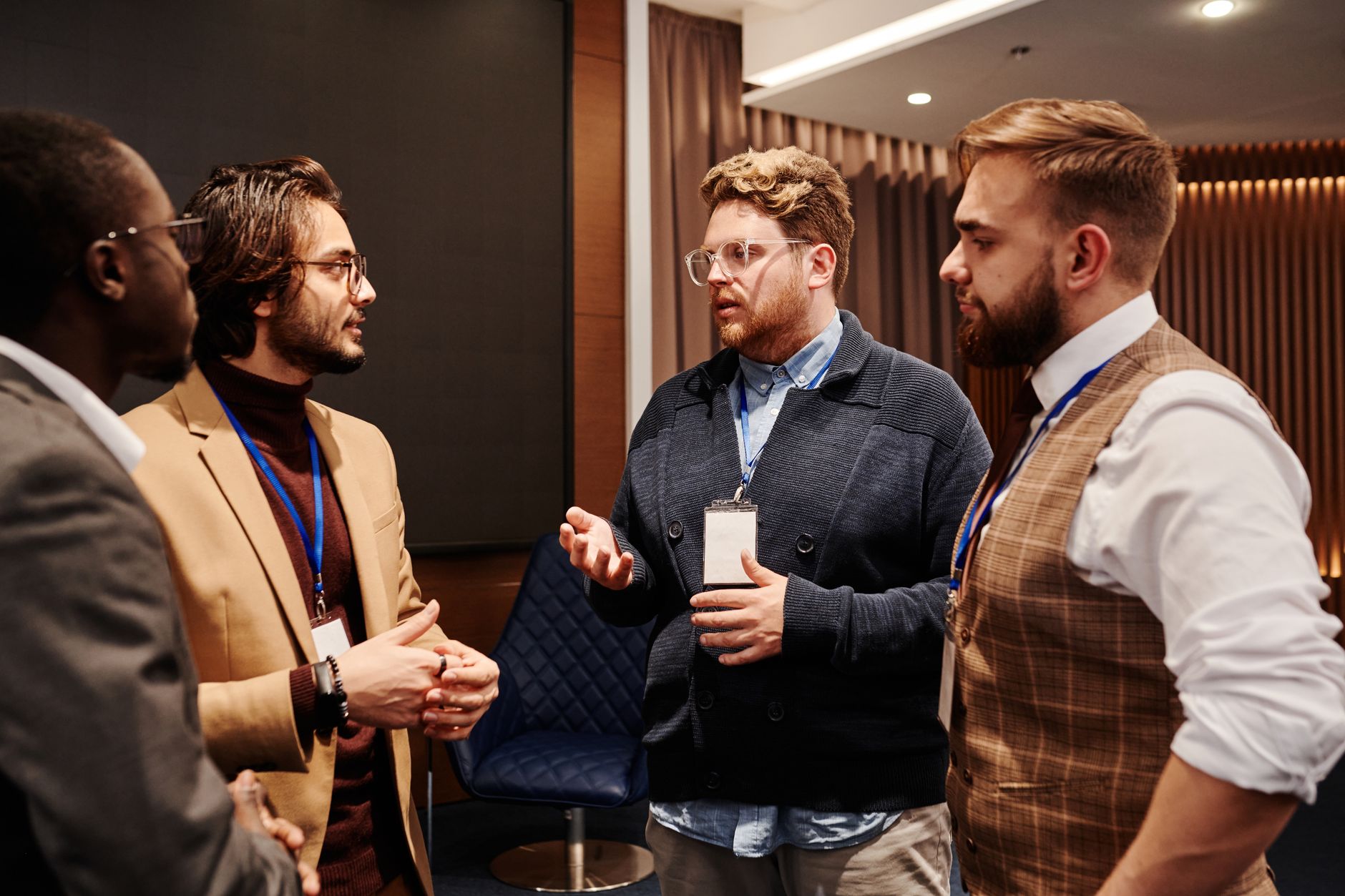 Four professionals wearing name badges talking at a networking event